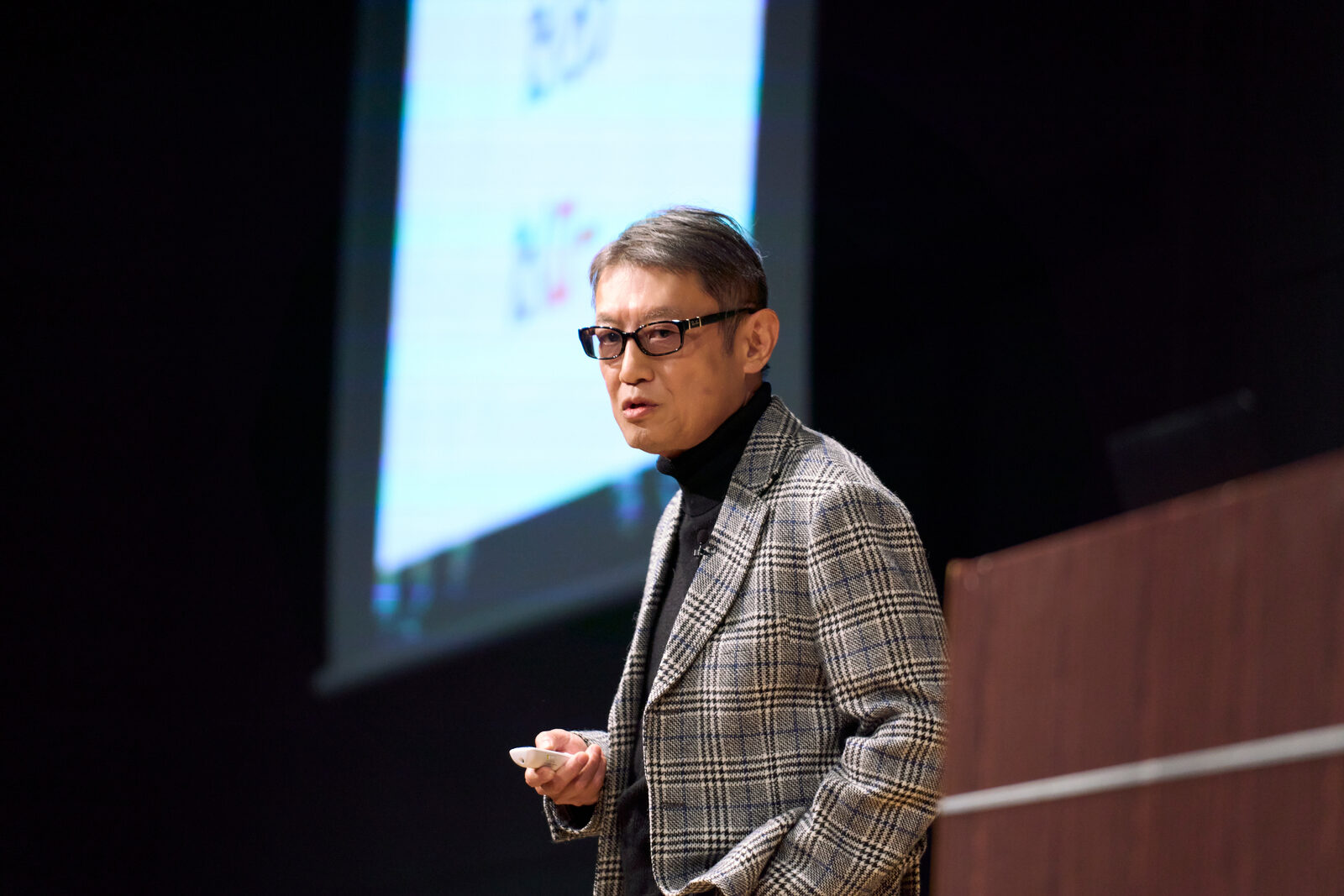 スクリーンを背に登壇して話す広木 隆