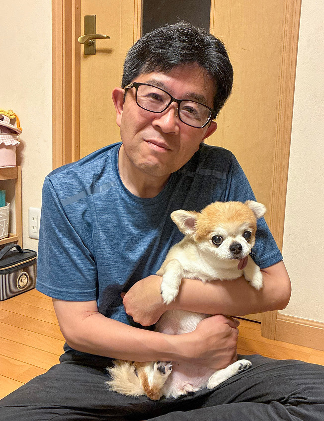 チワワのチャイちゃんを抱く吉田 恒